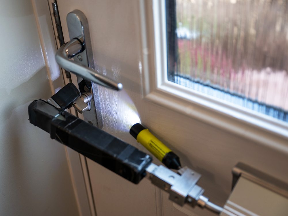 A locksmith using a letterbox bypass tool to open a composite door