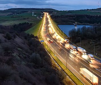 Evening traffic on the M62 trans-Pennine motorway beside a moorland reservoir, the main route serving the Halifax and Calderdale area