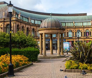 The Victoria Shopping Centre in the heart of Harrogate, its domed pavilion and neoclassical, copper-roofed arcade rising above the gardens near the railway station