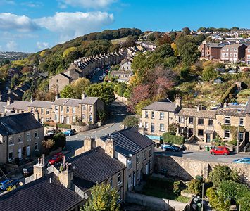 Stone terraced houses climbing the hillsides above Huddersfield, the characteristic layout of the town set among the Pennine foothills