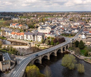 An aerial view over Wetherby, with the Grade II listed Wetherby Bridge crossing the River Wharfe and the market town beyond