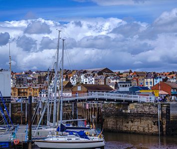 The footbridge over the entrance to Scarborough's old harbour, with the town's seafront houses behind — a short drive away