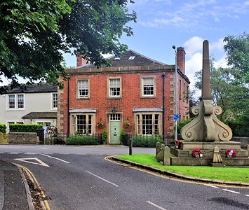The village of West Bretton, a handsome brick house and war memorial beside the lane at the centre of the village